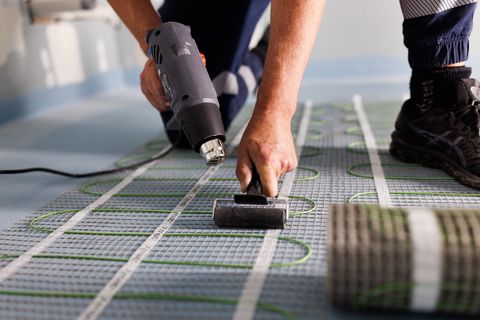 Pressing a heating mat down, with the next roll ready beside it